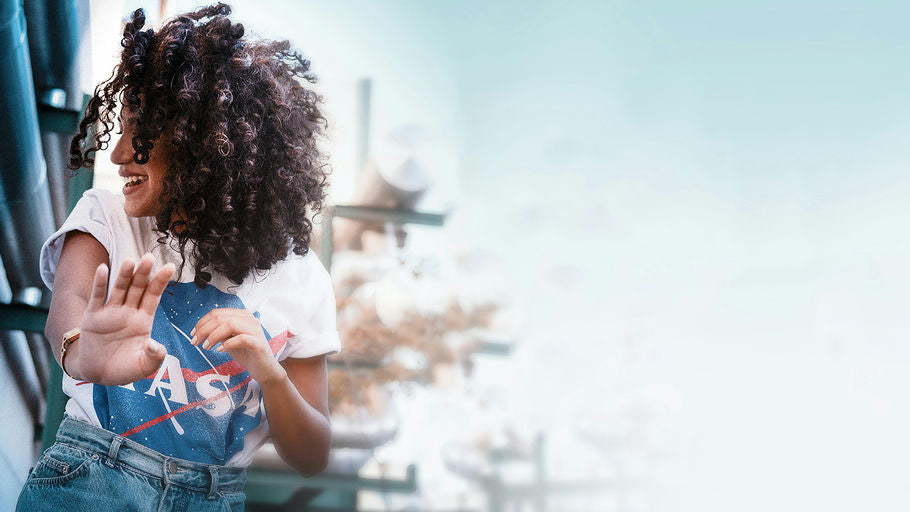 Image d'une femme souriante avec des cheveux longs et brillants, symbolisant la santé capillaire grâce à une hygiène efficace et des soins appropriés.