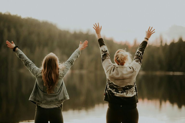 Femme souriante appliquant de l'huile naturelle sur ses cheveux, mettant en valeur les bienfaits des soins capillaires naturels pour un bien-être optimal dans un monde moderne trépidant.