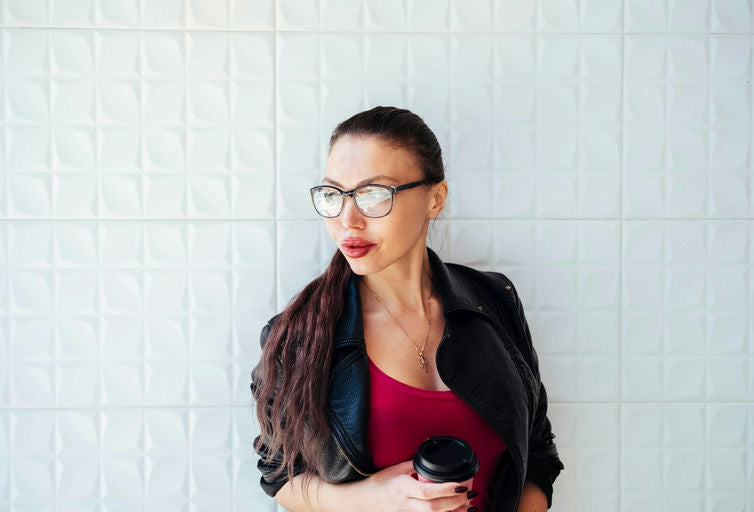 Femme appliquant de l'huile capillaire naturelle sur ses cheveux dans un cadre zen, symbolisant le bien-être et un mode de vie sain