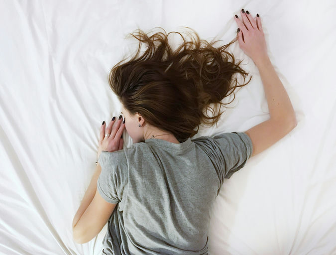 Femme appliquant de l'huile capillaire sur ses cheveux pour une routine de soins capillaires et d'hygiène