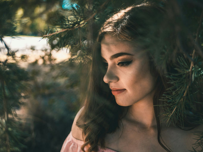 Femme appliquant un soin capillaire naturel sur ses cheveux devant un miroir