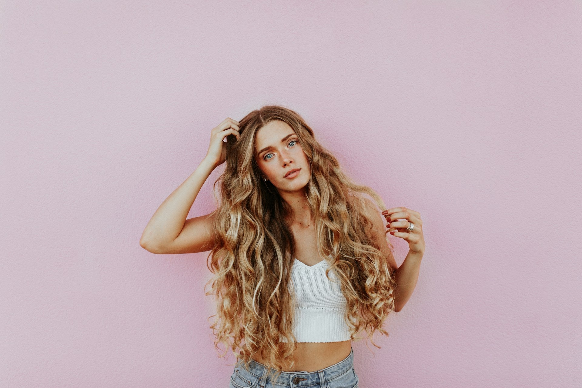 Femme appliquant de l'huile capillaire naturelle sur ses cheveux pour un bien-être optimal