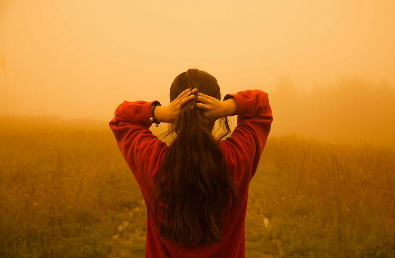 Femme appliquant de l'huile capillaire sur ses cheveux pour un soin naturel et personnalisable