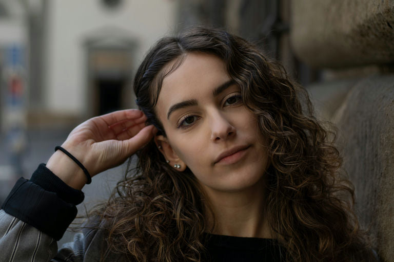 Femme avec des cheveux brillants et en bonne santé, illustrant les bienfaits d'une alimentation équilibrée et de soins capillaires naturels